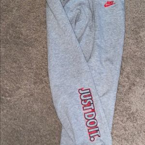 Gray Nike joggers, red Nike sign and print